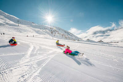 Kinder beim Schlittenfahren auf den Hängen von Tignes